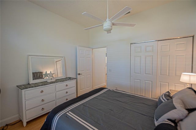 bedroom featuring high vaulted ceiling, light hardwood / wood-style floors, a closet, and ceiling fan