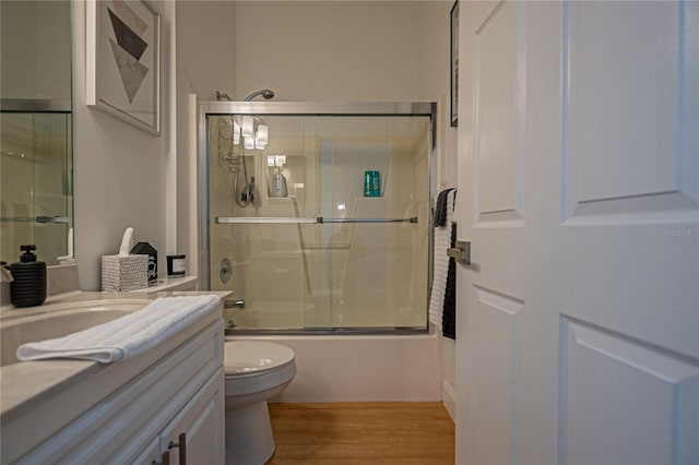 full bathroom featuring enclosed tub / shower combo, vanity, toilet, and hardwood / wood-style floors