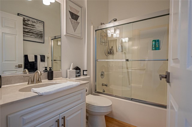 full bathroom featuring enclosed tub / shower combo, vanity, toilet, and wood-type flooring