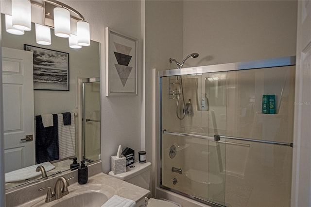 full bathroom with toilet, vanity, and bath / shower combo with glass door