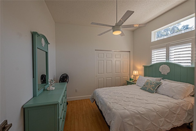 bedroom featuring ceiling fan, dark hardwood / wood-style floors, a textured ceiling, and a closet