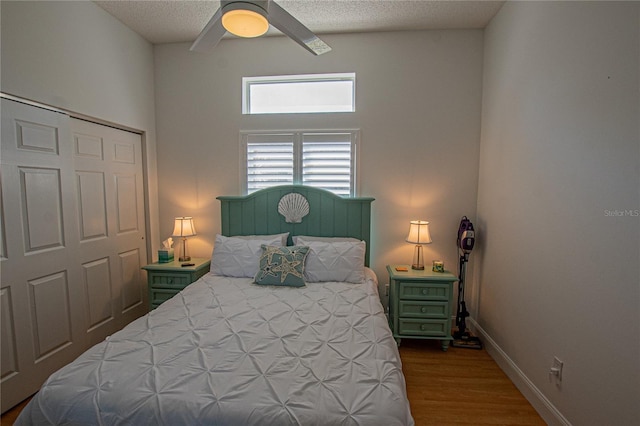 bedroom with ceiling fan, hardwood / wood-style flooring, a closet, and a textured ceiling