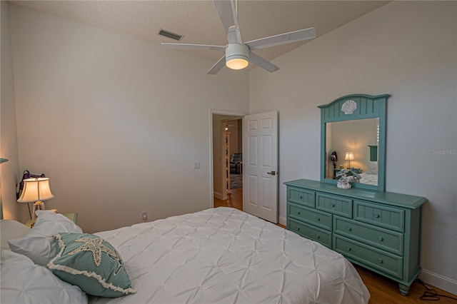 bedroom featuring vaulted ceiling, ceiling fan, a textured ceiling, and dark hardwood / wood-style flooring