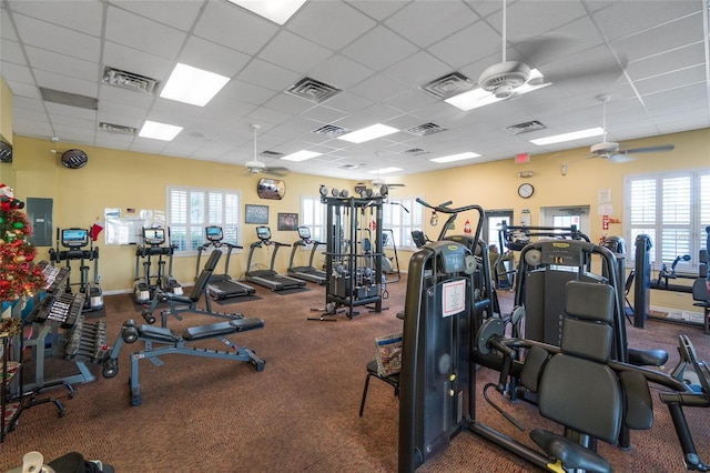 workout area featuring ceiling fan, a paneled ceiling, and a wealth of natural light