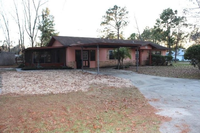 ranch-style home with a carport and a sunroom