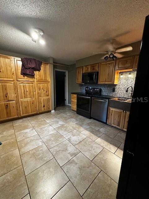 kitchen with sink, ceiling fan, tasteful backsplash, black appliances, and a textured ceiling