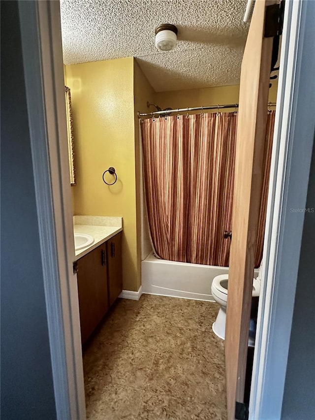 full bathroom featuring shower / bath combo, vanity, a textured ceiling, and toilet