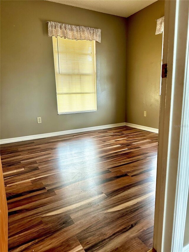 empty room featuring dark wood-type flooring