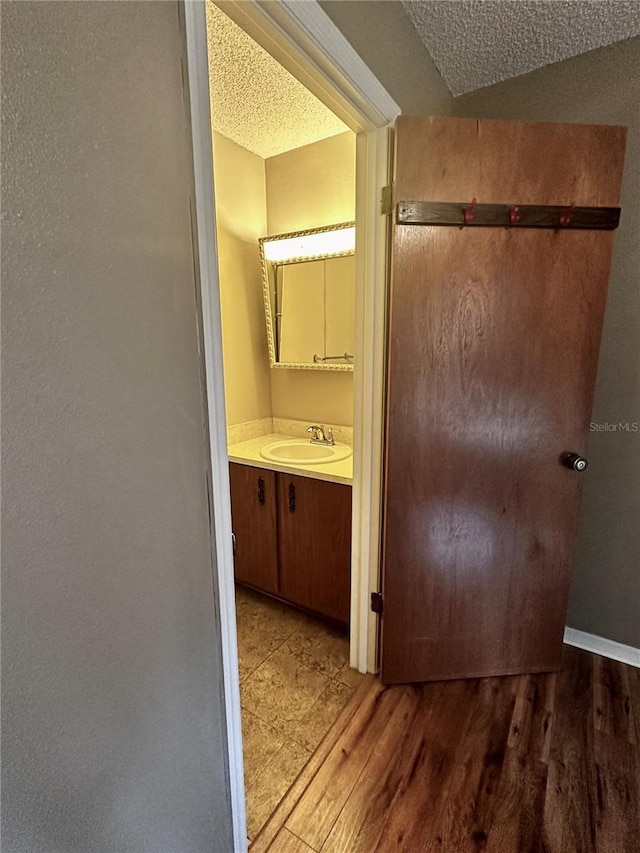 bathroom featuring wood-type flooring, a textured ceiling, and vanity