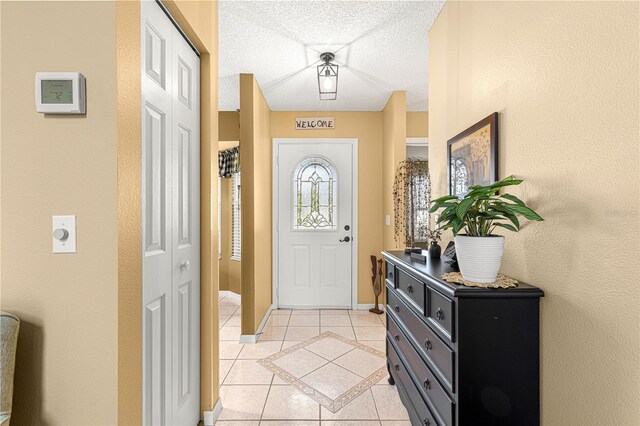 foyer featuring light tile patterned flooring and a textured ceiling