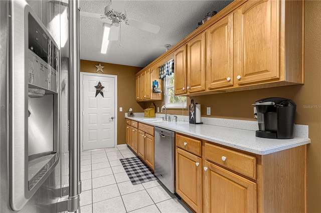 kitchen featuring dishwasher, sink, fridge, light tile patterned floors, and a textured ceiling