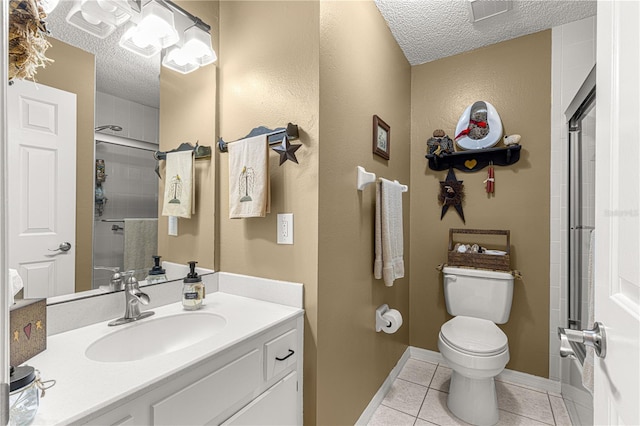 bathroom featuring tile patterned floors, toilet, a textured ceiling, and vanity