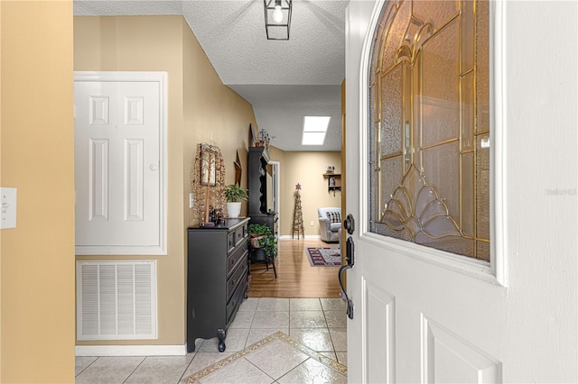 entrance foyer featuring light tile patterned floors and a textured ceiling