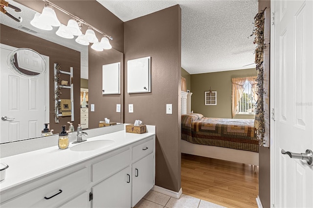 bathroom with vanity, tile patterned flooring, and a textured ceiling