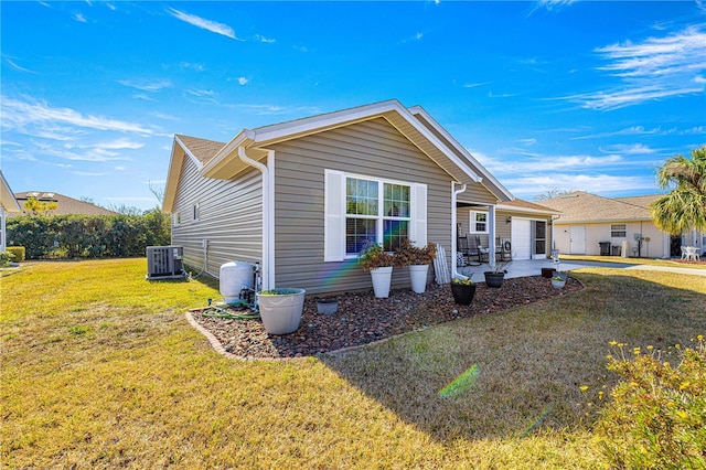 view of front of home with a front yard, a patio area, and cooling unit