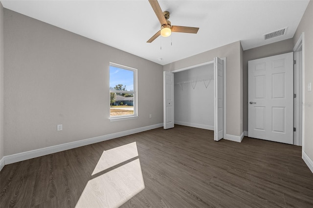 unfurnished bedroom with dark wood-type flooring, ceiling fan, and a closet