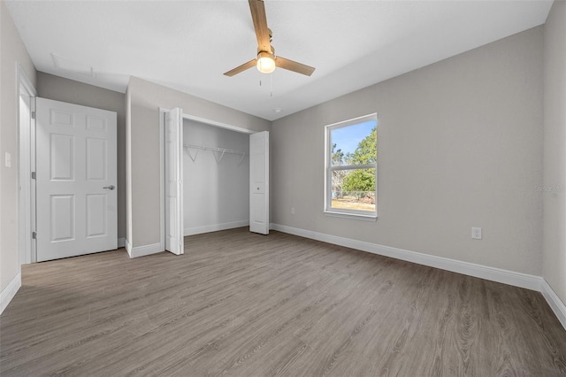 unfurnished bedroom featuring ceiling fan, a closet, and light wood-type flooring