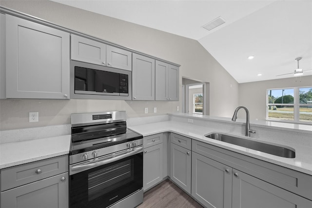 kitchen with built in microwave, gray cabinets, sink, and electric stove