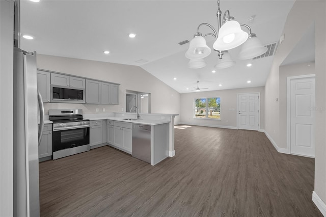 kitchen with lofted ceiling, sink, appliances with stainless steel finishes, gray cabinets, and kitchen peninsula