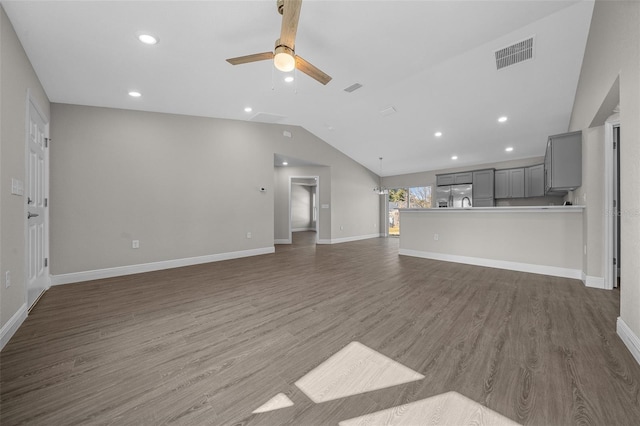 unfurnished living room featuring dark wood-type flooring, ceiling fan, and vaulted ceiling