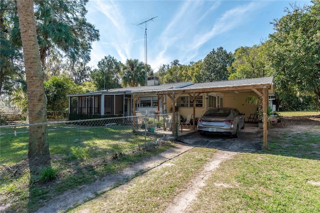 view of front facade with a carport, a sunroom, and a front lawn