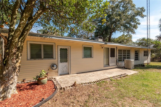 back of house with a yard, central AC unit, and a patio area