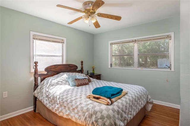 bedroom featuring multiple windows, ceiling fan, and light hardwood / wood-style flooring