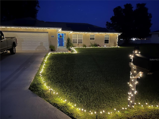 ranch-style home with a garage and a lawn