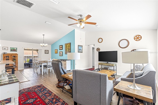 living room with wood-type flooring, lofted ceiling, ceiling fan with notable chandelier, and a textured ceiling