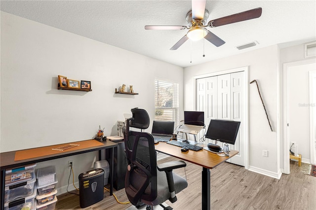 office area featuring ceiling fan, light hardwood / wood-style flooring, and a textured ceiling