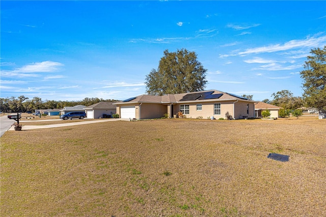 single story home with a garage, a front lawn, and solar panels