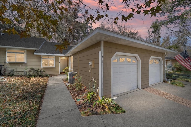 view of front of home featuring a garage and central AC