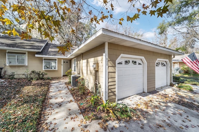 view of property exterior with a garage and central AC