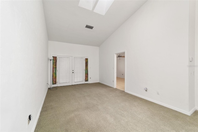 unfurnished bedroom featuring light colored carpet and high vaulted ceiling