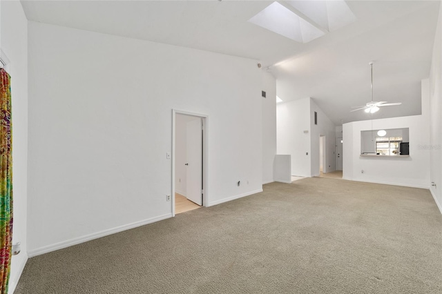 unfurnished living room with high vaulted ceiling, light carpet, ceiling fan, and a skylight