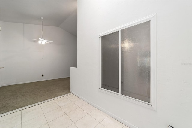 carpeted empty room featuring vaulted ceiling and ceiling fan