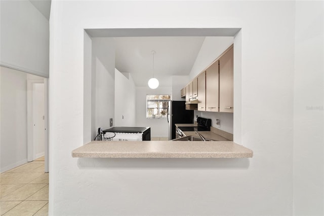 kitchen featuring stainless steel refrigerator, kitchen peninsula, light tile patterned floors, and electric range