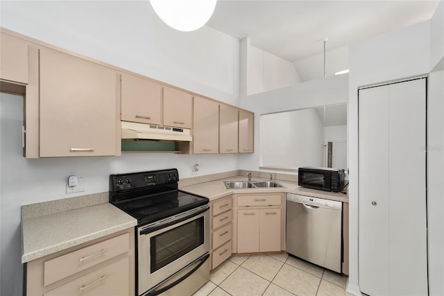 kitchen featuring light tile patterned flooring, stainless steel appliances, light brown cabinetry, and sink