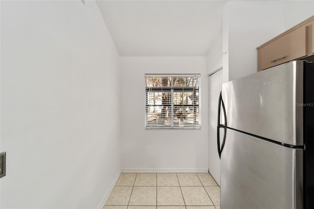 kitchen featuring light tile patterned flooring and stainless steel fridge