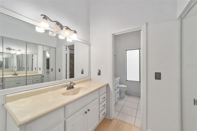 bathroom with tile patterned flooring, vanity, and toilet