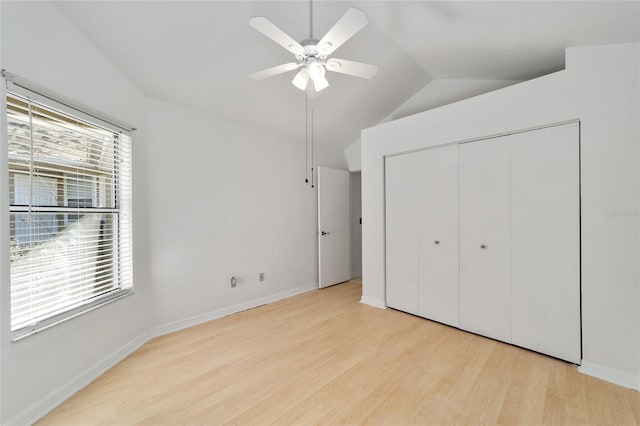 unfurnished bedroom with a closet, lofted ceiling, ceiling fan, and light hardwood / wood-style flooring