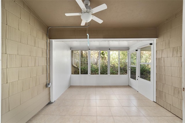 unfurnished sunroom with ceiling fan