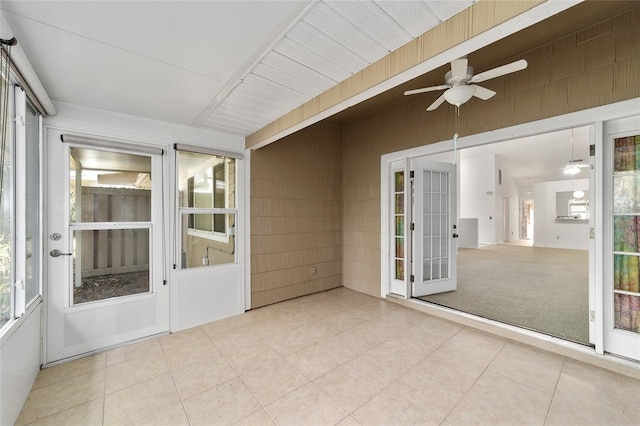 unfurnished sunroom with ceiling fan