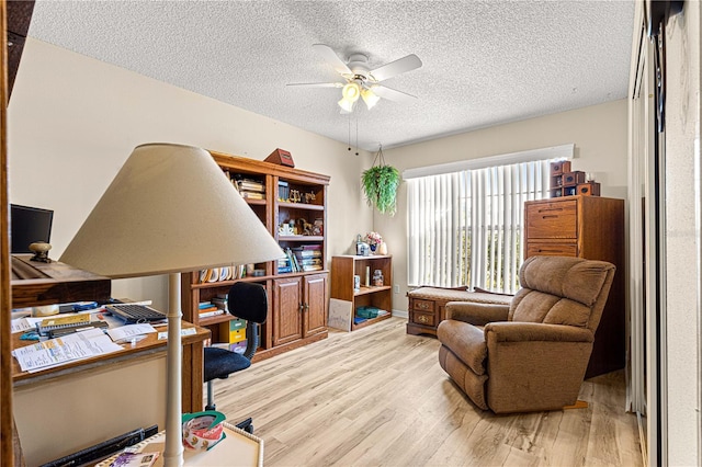 office space featuring ceiling fan, light hardwood / wood-style floors, and a textured ceiling