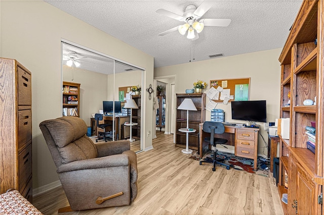 office space featuring ceiling fan, a textured ceiling, and light hardwood / wood-style flooring