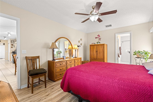 bedroom featuring a textured ceiling and light hardwood / wood-style flooring