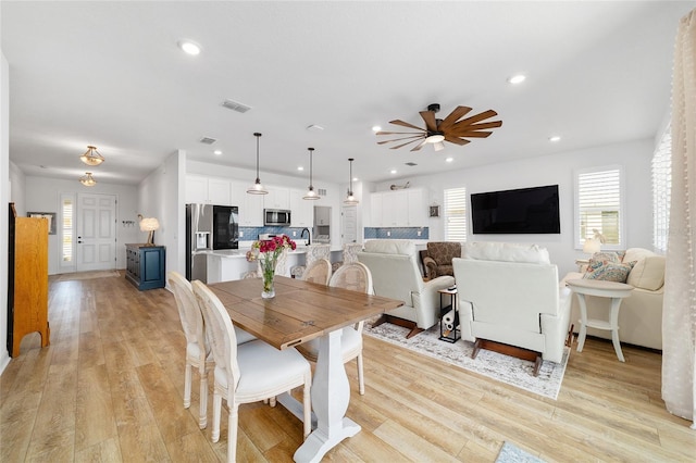 dining area with sink, light hardwood / wood-style floors, and ceiling fan