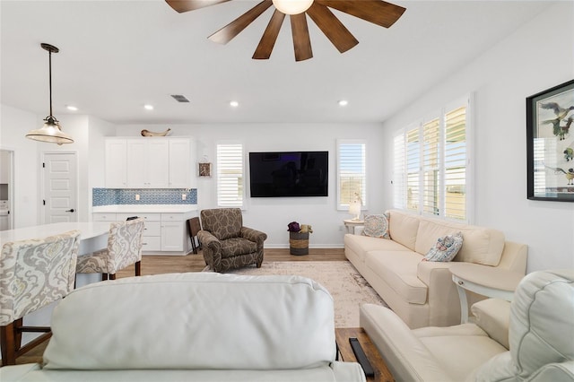 living room with ceiling fan and light wood-type flooring