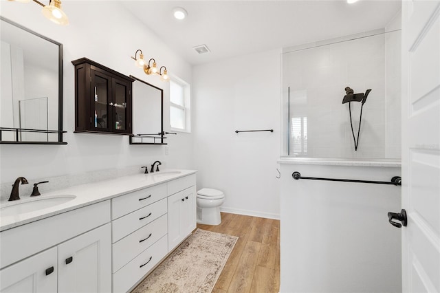 bathroom with vanity, hardwood / wood-style floors, toilet, and a shower