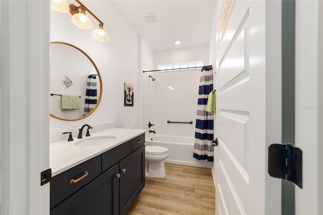 full bathroom with shower / tub combo, vanity, wood-type flooring, and toilet